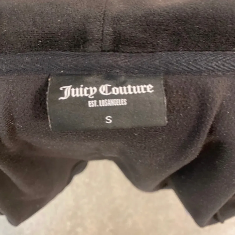 En juicy couture kofta som är helt svart. Ända nackdelen är att en av metall bitarna på snöret är av och därför säljs den för ett mycket lägre pris. Tröjor & Koftor.