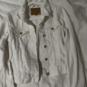 En vanlig vit jeans jacka, som man kan justera på sidorna. 