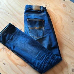 Nudie jeans Grim Tim - Ett par Nudie jeans i färgen indigo myth modellen är grim tim och storleken är 32/32. Köpta på NK. Bara höra av om ni är intresserade, eller om ni vill ha fler bilder för skick och så vidare 