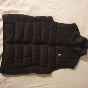 Lyle & Scott väst - Svart Lyle & Scott väst Storlek XS Använt ett par gånger men är fortfarande i väldigt bra skick. Anledningen till att jag säljer västen är att den har blivit för liten för mig. 