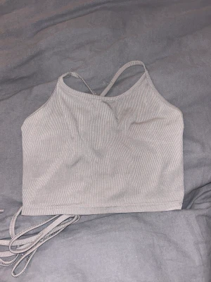 Topp - Grå topp med snörning i ryggen.  Står inte för frakten 