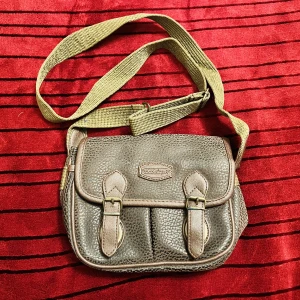 Vintage dam axelrem väska i skinn - Vintage dam axelremväska i skinn.  Färg: Svart/brun Små fack finns fram och bak, samt 2 separata inre fack.  Ej använd. 