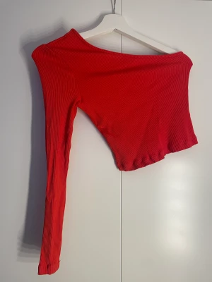 Tröja med en arm - Röd tröja med en arm från nakd, storlek xs. Tröjan är ribbad (se bild 2). Använd endast 1 gång så den är som ny. 50 kr + frakt🫶🏼