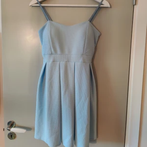 Blå klänning  - Superfin blå klänning som aldrig kommit till användning. Inlägg vid bröstet.