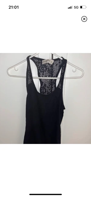 Linne med detaljer  - Linne från abercrombie med spetsliknade detaljer upptill samt över ryggen. Storlek xs