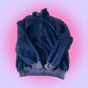 En blå ”sammets-aktig” tröja med liten zip. Små skador vid ärmarna (bild två) som jag tror gå att sy ihop, från gam. ägaren, okej skick. Vid högt intresse gäller budgivning annars först till kvarn! +59kr frakt