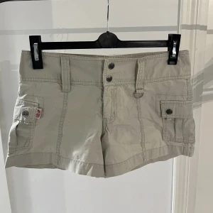 Lågmidjade Cargo Shorts - För er som älskar Vintage kläder är dessa lågmidjade cargo shorts PERFEKTA för er. Dem är super snygga och går inte att hitta någonstans. Dem är beiga och så himla snygga. Köpta för säkert över 10 år sedan men inget jag kan använda. Ungefär storlek S/XS💘