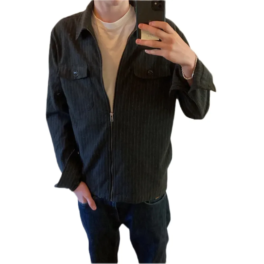 Fräsch grå randig overshirt från dressman med zip, den har två synliga fickor och dolda fickor vid sidan av magen, priset kan diskuteras, skriv vid funderingar. Storlek S men passar M. Jackor.