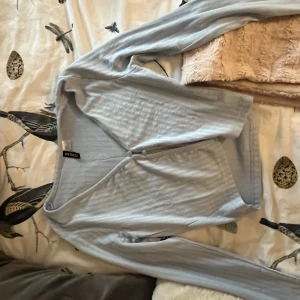 Blus från H&M - Ljusblå kort blus från H&M. Magen syns bra med lågmidjade jeans och det kan vara bra med en topp under. Den är ribbad och väldigt söt men använder ej och endast använd ett fåtal gånger 2021. 