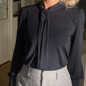 Marinblå Ralph Lauren blus - Blus från Ralph Lauren med fina guldknappar. Blusen har extremt vackra armar som ger en elegant look. Framtill finns ett snöre.