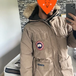 Canada Goose jacka - Beige Canada Goose jacka. Superbra jacka och har varit supernöjd med den då den är varm och klarar väldigt kallt. En del år på nacken därav priset. Slitage finns men inte såpass att det påverkar funktionen. Äkta päls på luvan. Stor i storleken tycker jag.