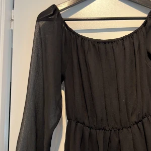 Klänning  - Genomskinliga ärmar. Man kan ha ärmarna på axlarna eller nedhasat. Enkel klänning men som också passar till fest!