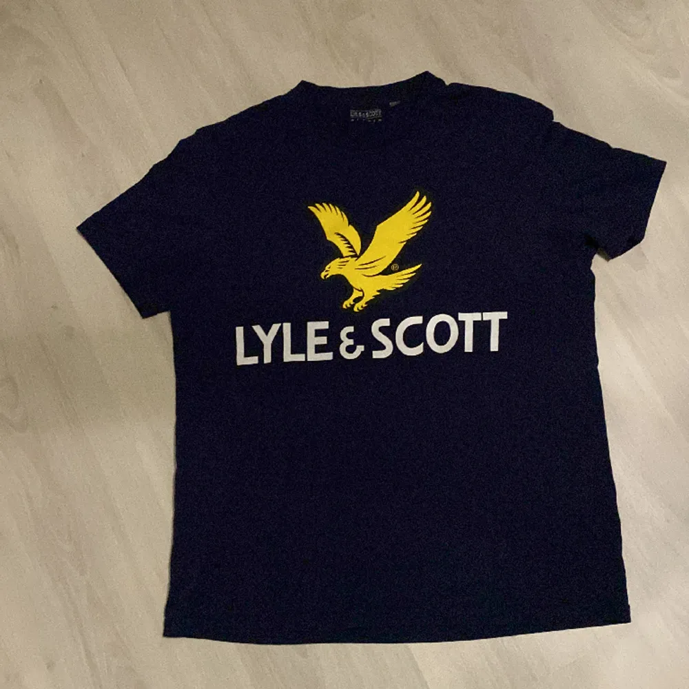 Marin blå Lyle & Scott t-shirt i bra skick, storlek L men passar även M. T-shirts.