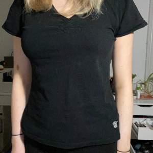 En vanlig söt svart T-shirt med en liten silverkrona i vänstra hörnet.  Använd typ 2 gånger 