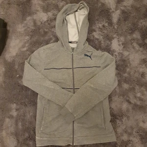 Puma Zip Hoodie  - Tröjan har använts och det finns några missfärgningar på den. Storleken är 13-14 år, men den sitter som XS.