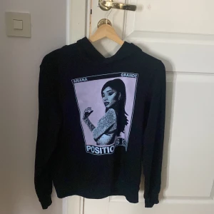 Svart hoodie med tryck - Svart hoodie med ett stort Ariana Grande tryck på framsidan, använd få gånger men trycket är lite lite slitet