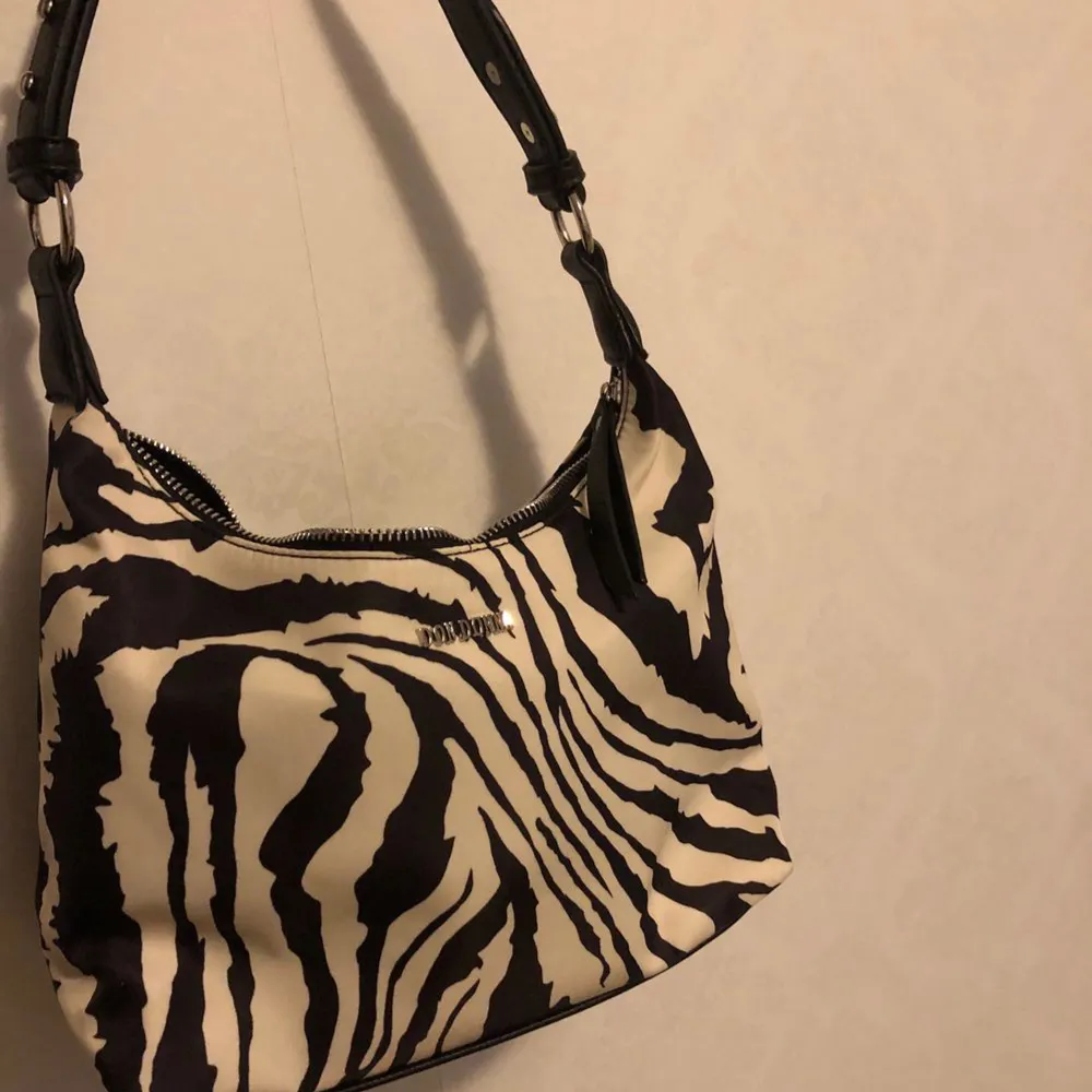Don Donna zebra-print bag, använd fåtal gånger och i nyskick. Bra fest-väska och helt slutsåld, köpt för 599kr skriv för fler frågor🤩. Väskor.