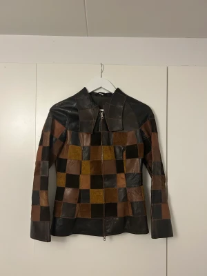 Skinnjacka med patches - Säljer min supersnygga skinnjacka då den tyvärr är för liten. Står ingen storlek eller märke i jackan men skulle säga att den passar storlek S och XS. Köpt vintage, men aldrig använd av mig. Fint skick! 🌟