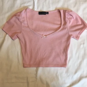 Rosa crop topp med rosett - - Plagg: Rosa crop top - Mönster: Inget - Färg: Ljus Rosa/ babyrosa - Storlek: XS - Märke: Pretty Little Things - Skick: Väldigt bra (Köpt på plick, Aldrig använt av mig) - Egenskaper: Ribbad, rosett, kepsärm  Kontakta mig gärna vid frågor 💕 