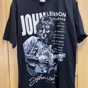 En helt ny och oanvänd T-shirt med John Lennon på trycket.