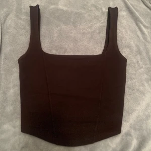 Kortsett formad topp  - Fin brun korsett formad crop top. Linne crop topp blus tröja top. Passar storlek S. Antingen från Gina Tricot / hm / bikbok (kollar upp det snart). Super fin på allt! Fyrkantig halsringning som är väldigt smickrande.