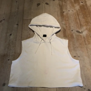 Vit Hoddie utan armar 🤍✨ - En vit Hoddie utan armar från Gina tricot. Den är väldigt kort, typ till naveln. Säljer den för att jag inte använder den längre. Bra skick och storleken är S. Hoppas den får användning hos någon annan. 💗🤍✨