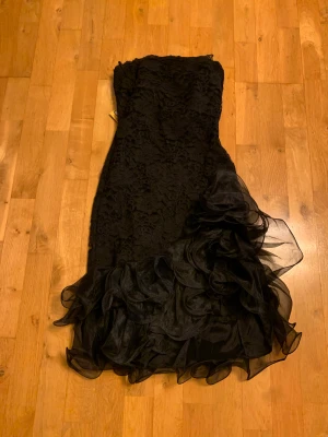 Svart festklänning  - Fin svart festklänning från beyond retro. Spets och tyll detaljer. Aldrig använd och lappen sitter kvar. Skriv privat för fler bilder.