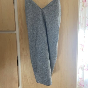 Glittrig klänning  - Glittrig klänning med spagetti straps. Kort med v ringning. Jättefin att ha till nyår. Dock aldrig använd! 