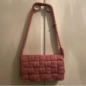 Virkad väska i rosa gjord efter inspiration av Bottega Venettas Casette väska. Väskan är rymlig och har ett eget handtag. längd: 30cm höjd: 16cm bredd:6cm Pris: 900kr+porto OBS! Katter finns i hushållet