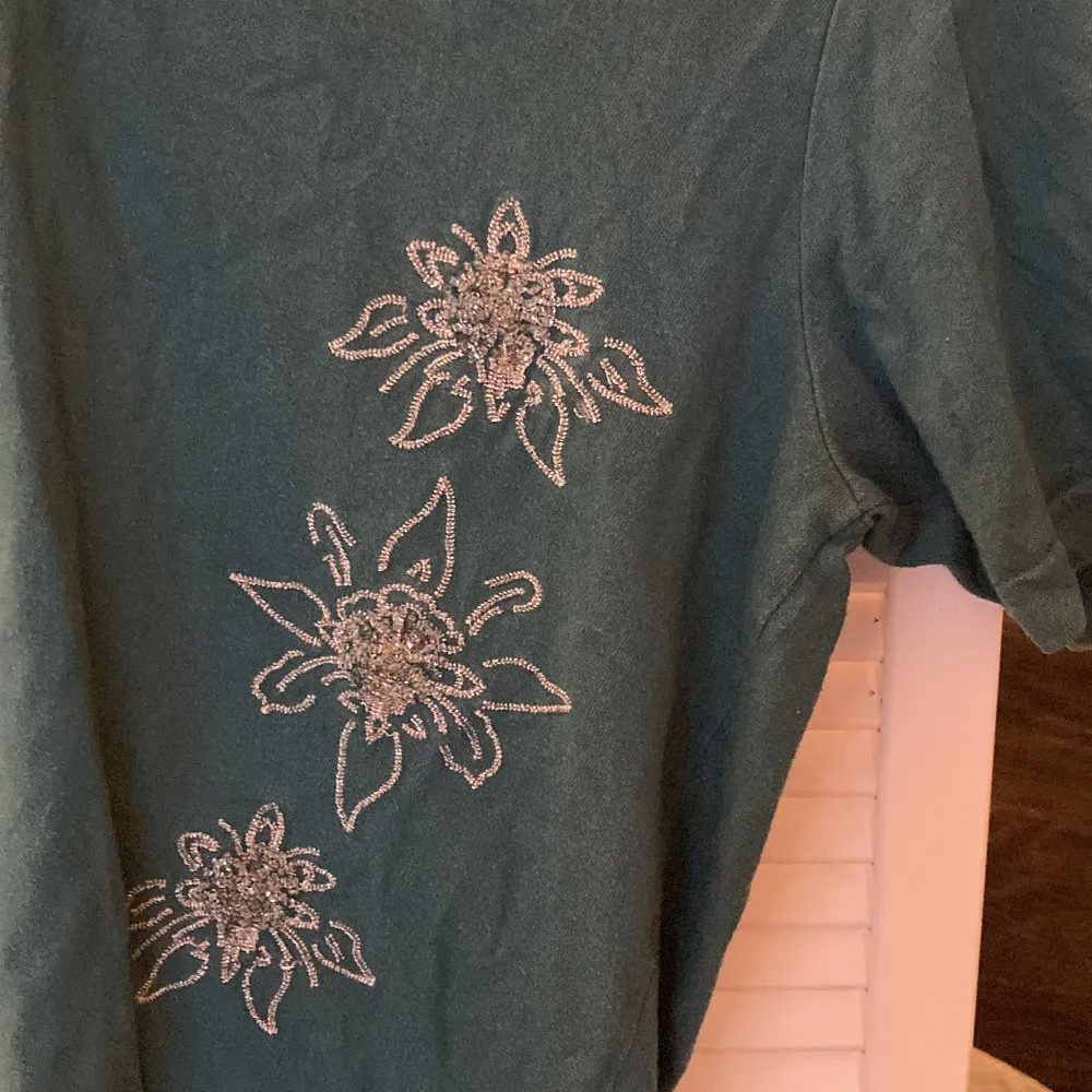 en super söt T-shirt med små blomster motiv i paljetter!! . T-shirts.