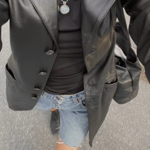 Äkta läderkappa  - Äkta läderkappa köpt på sellpy! Figursydd, och fina axlar som framhäver siluetten! Sparsamt använd 