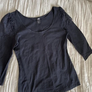 Svart topp - Elegant svart topp med spets på axlarna 