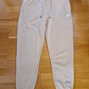 Mjukisbyxor stl L Nike - Beiga mjukisbyxor stl L från Nike,dragsko i midjan. Djur och rökfria, finns i Hyllinge, har swish.