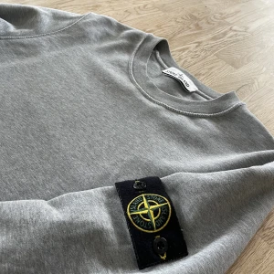 Ljusgrå Stone Island Crewneck - Säljer pågrund av den är för stor. Har använts några gånger. Skick 9/10 Kvitto finns