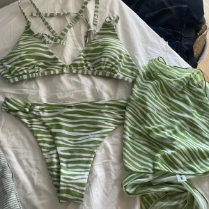 Grön randig bikini - Shein bikini som är helt oanvänd pågrund av för liten. Den är i bra skick. Kommer tillsammans med en sjal att knyta runt midjan. 