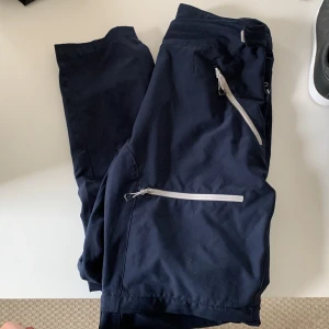 Friluftsbyxor - Går att ta av till shorts.  Går att spänna runt vrister och midja Sammanlagt 4 fickor