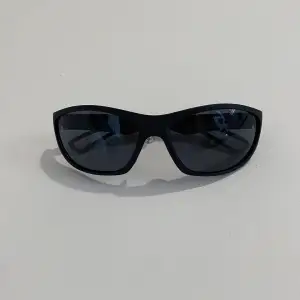 Enkla wrap-solglasögon i svart plast. Mycket gott skick.
