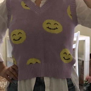 Stickad väst med smiley - Lila Stickad väst med gula smiley. Monki. Storlek S.   ☺️ 💜