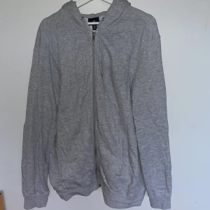 Grå Zip Hoodie - Säljer denna grå zip-hoodie från hm. Enbart använd en gång så nyskick. Storlek XL. 