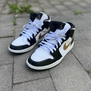 Jordan 1 mid patent black gold  - Säljer dessa Jordans 1 mid patent black gold i storlek 42. Nypris på dessa skor är 3300kr. Mitt pris är 750kr. Inte nya men i nyskick.  Finns att hämta i Huddinge, Tullinge eller stan.