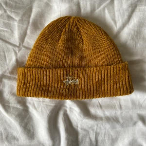Stussy mössa - Säljer en orange stussy mössa som köptes för ett tag sen, den är ganska använd men det finns inga synliga defekter eller liknande köptes för ca 499kr. Tar endast swish köpare står för frakt.
