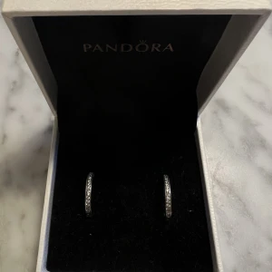 Pandora örhängen - Hoops från pandora i sterling silver. Nästintill oanvända, svåra att få på bild men är samma som de från hemsidan på bild 3. Originalpris är 740kr, säljer dessa för 300kr.