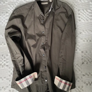 Burberry skjorta  - Grön/olivgrön oanvänd, jättebra skick. Nypris 2700, säljs pågrund av storleken. Priset kan diskuteras.