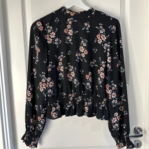 Blommig blus med smock  - Svart blus med blommor från H&M divided. I chiffong. Använd ca 2 gånger och har inga defekter🫶🫶