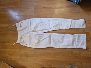 Vita byxor - Vita byxor i tunt svalt material. Skulle funka asbra till sommarn. Liknar linnebyxor.