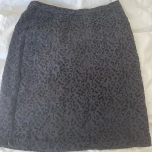 Svart, tight kjol med ett diskret leopardmönster och dragkedja där bak  Strl. Xs Nypris: 300kr  Köpt i någon butik - märke: peppercorn