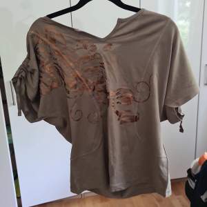 En t-shirt/topp med tryck knuttar och slits oandvänd