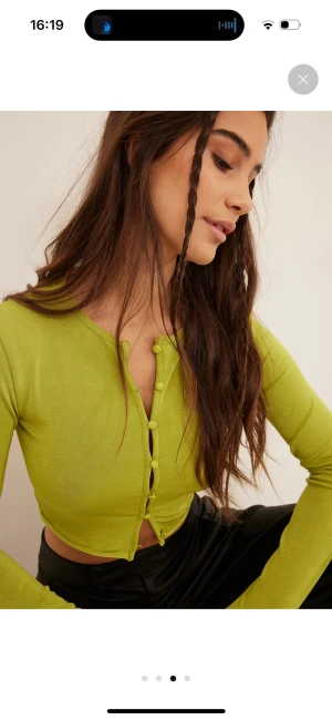 Grön långärmad topp med knappar - Säljer denna topp från NA-KD då den aldrig kommit till användning. Superfint lite skimmrigt tyg med knappar hela vägen framtill. 