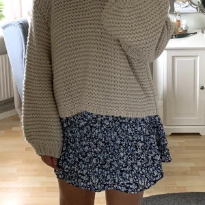 Blommig kjol - Svart, vit & blå blommig kjol från Lindex. Sparsamt använd. Den har resår bak i midjan så den är superskönt att ha på sig och är väldigt luftig och lätt.