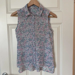 Ärmlös blus i semi-seethrough - Fin blommönstrad blus utan ärmar i skirt material som är halvt genomskinligt